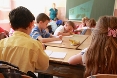 Children writing notes in classroom